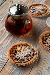 Close up of a nuts gluten free tartlet with honey, almonds and walnut with black tea