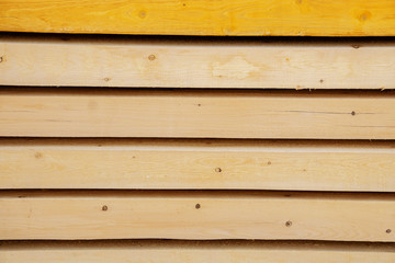 Wood processing. Wooden planks made of larch for building a house on a stacked structure. The details of the production of wood, selective focus. Organic material
