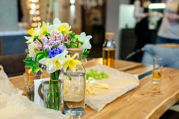 A bouquet of spring flowers on the kitchen table. Daffodils, hyacinths in a vase in the kitchen.