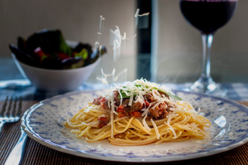 spaghetti pasta with bolognese sauce and parmesan cheese on the plate