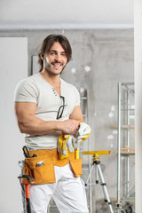 Friendly builder wearing a tool belt and gloves