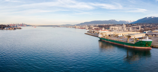 Obraz premium Aerial drone shot of a industrial shipyard and cargo ship loading port with cargo ships in Vancouver, BC, Canada.