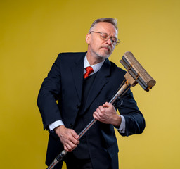 Adult man singing in mop. Holding broom like microphone. Man in suit.