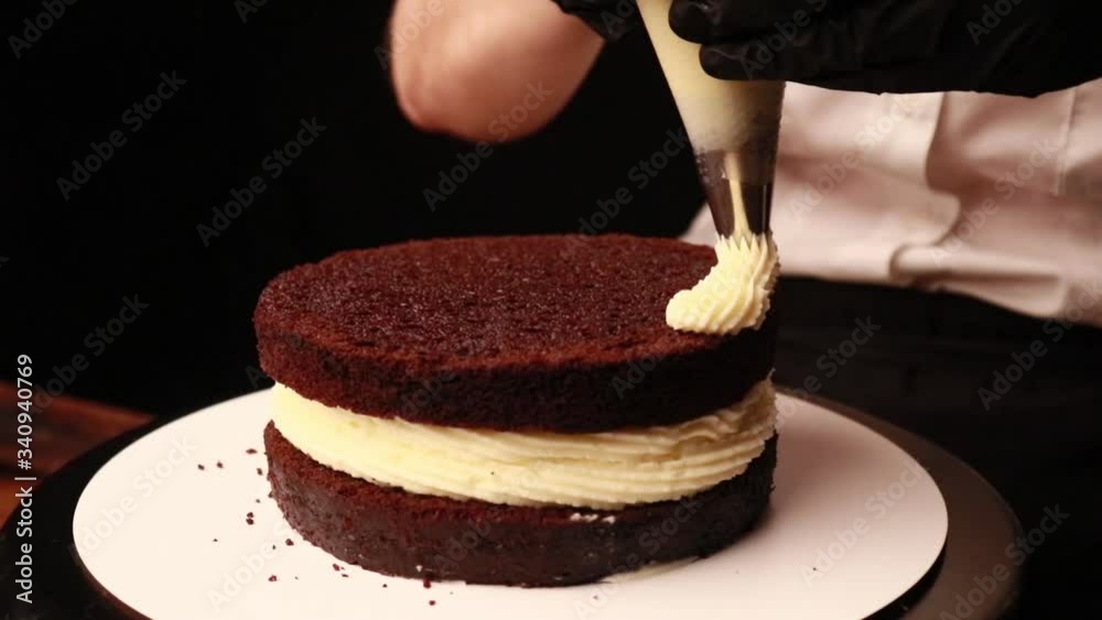 Wall mural cooking cake with female hands in black gloves