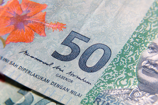 Super macro photography of 50 Ringgit Malaysia. Extreme close up on a RM 50 banknote. In center the big 50. On one side the red hibiscus flower on the other side the first Malaysian Agong.