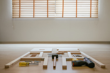 Furniture assembly parts and wood work tools on wooden floor for DIY do it yourself