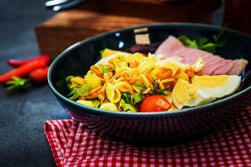 Salad made with cooked pasta, mixed green salads, cherry tomatoes, Mozzarella cheese and smoked ham served with accompaniment