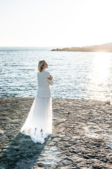 Fototapeta na wymiar Woman on the sea in white long dress