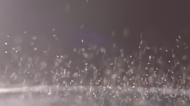 Trembling loudspeaker throwing white flour in the air. Super slow motion close-up shot.