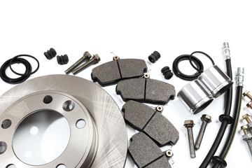 brake parts on white: brake pads, disc, brake hose, guides, cylinders .