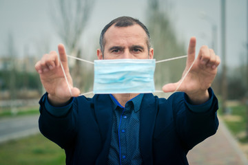Put on the mask! medical mask in the hands of a man. The end of the coronavirus pandemic. Protection against disease and infection. 