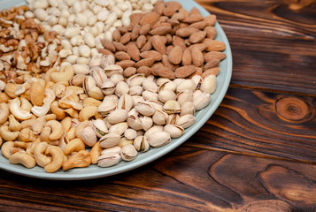 Assortment of nuts on a plate. Wooden board. Healthy snack. Flat lay