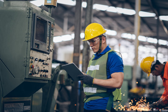 technician engineer checking process on tablet to machinery in factory
