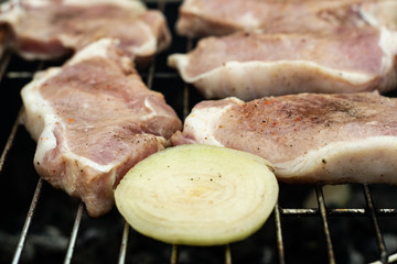 A strip steak newly placed on a charcoal grill