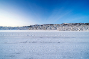Fototapeta na wymiar Icy road against snowcapped mountain