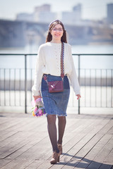 beautiful girl walks with a bouquet of spring flowers along the promenade