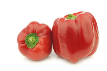 two red bell peppers (capsicum) on a white background