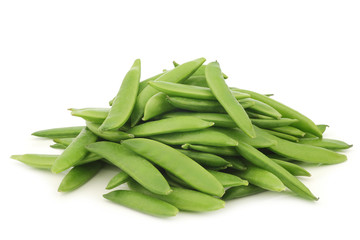 freshly harvested sugar snaps in a wooden box on a white background