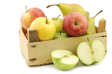 Fresh pears and apples in a wooden crate on a white background