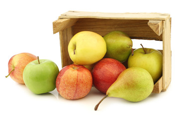 Fresh pears and apples in a wooden crate on a white background