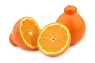 one fresh minneola and a cut one on a white background