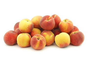  fresh colorful peaches (donut peaches) on a white background