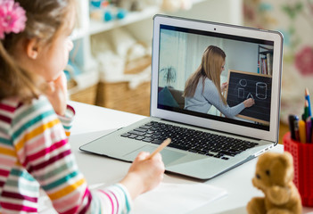 Young female distance teacher having video conference call with pupil using webcam. Online education and e-learning concept. Home quarantine distance learning and working from home.