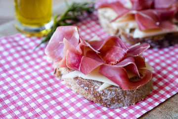 Bruschetta au fromage gruyère et jambon de parme avec un trait d'huile d'olive au romarin