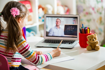 Middle-aged distance teacher having video conference call with pupil using webcam. Online education and e-learning concept. Home quarantine distance learning and working from home.