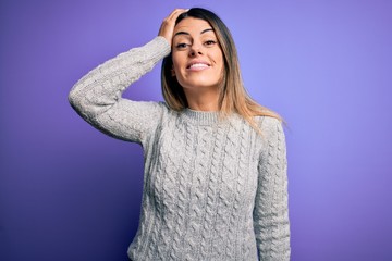 Young beautiful woman wearing casual sweater standing over isolated purple background confuse and wonder about question. Uncertain with doubt, thinking with hand on head. Pensive concept.