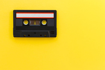 Retro audio tape cassette from 80s and 90s isolated on yellow background. Old technology concept....