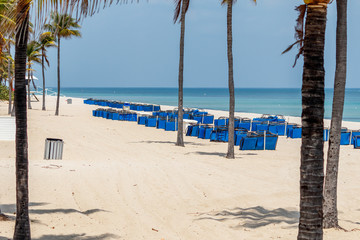 Fototapeta na wymiar Fort Lauderdale, Florida / USA - 4/10/2020: No tourist and empty chaises lounge beach chairs after spring break due to beach closed to residents & local public from covid 19 coronavirus outbreak.