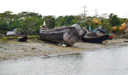 Old harbor of different sized wooden fishing boat,where the boats are grounded safely
