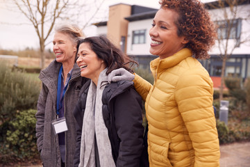 Group Of Smiling Female Mature Students Walking Outside College Building