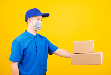 Fototapeta na wymiar delivery worker man wearing face mask protective giving cardboard boxes