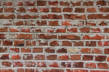 Old weathered red brick wall as a background. The repeating texture of a red brick wall is often...