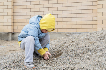 a girl plays with crushed stone on the self-insulation . coronavirus