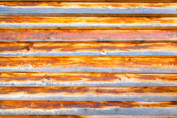 Background textured old wall of brown and orange style wooden beams. The wall of an old country house.