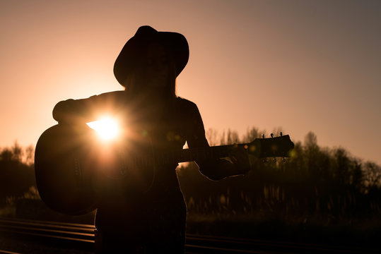 Woman playing guitar on rails