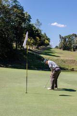 Obraz premium Man playing golf on a golf course.