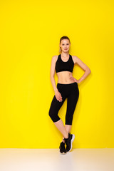 Fototapeta na wymiar young woman doing exercise on yellow background