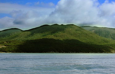 Mountain and sea. Blue sky. In the foreground is the holoboy sea. The mountain is in the background. The serpent, part of the mountain in the shade. Copy space.