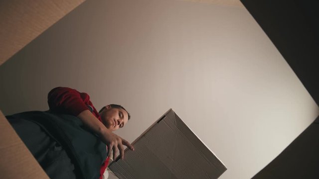 A young man takes a small box out of the cartoon box