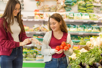 Teen girls shopping at the supermarket. Young people make the conscious, organic and healthy choice.