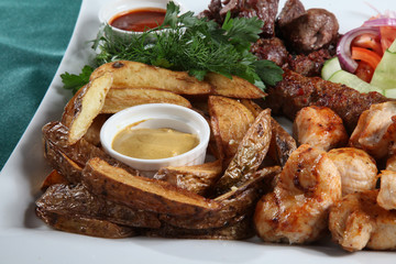Julien framed with fried potatoes, kebab, dill, onion, tomatoes on the background of a Lula