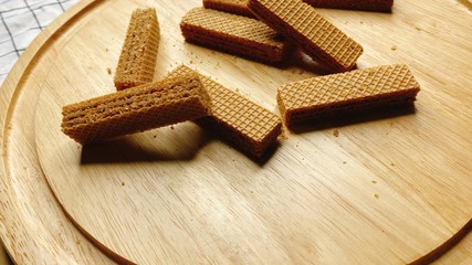 Baked crispy chocolate and coffee Wafers on wooden plate.