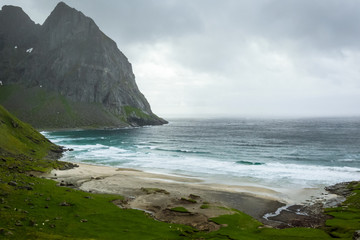 Beautiful wild beach with cliffs on background 