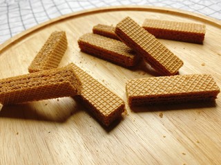 Baked crispy chocolate and coffee Wafers on wooden plate.