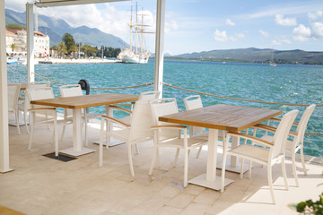 Fototapeta na wymiar Cozy empty open cafe on the sea promenade, Tivat, Montenegro.