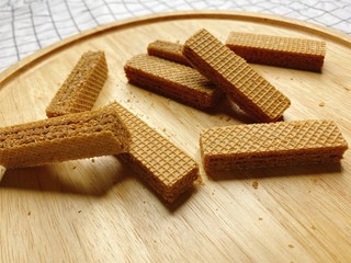 Baked crispy chocolate and coffee Wafers on wooden plate.